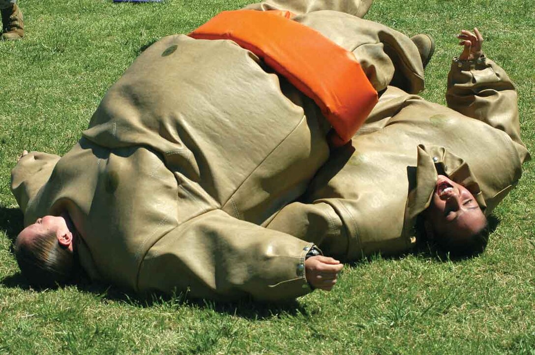 Lance Cpl. Emily Sample (left), Headquarters and Headquarters Squadron administrative clerk, and Pfc. Tatiana Sandoval, H&HS Traffic Management Office specialist, take a breather after sumo wrestling at the Single Marine and Drug Demand Reduction programs? barbeque April 7 at softball 545 field here.