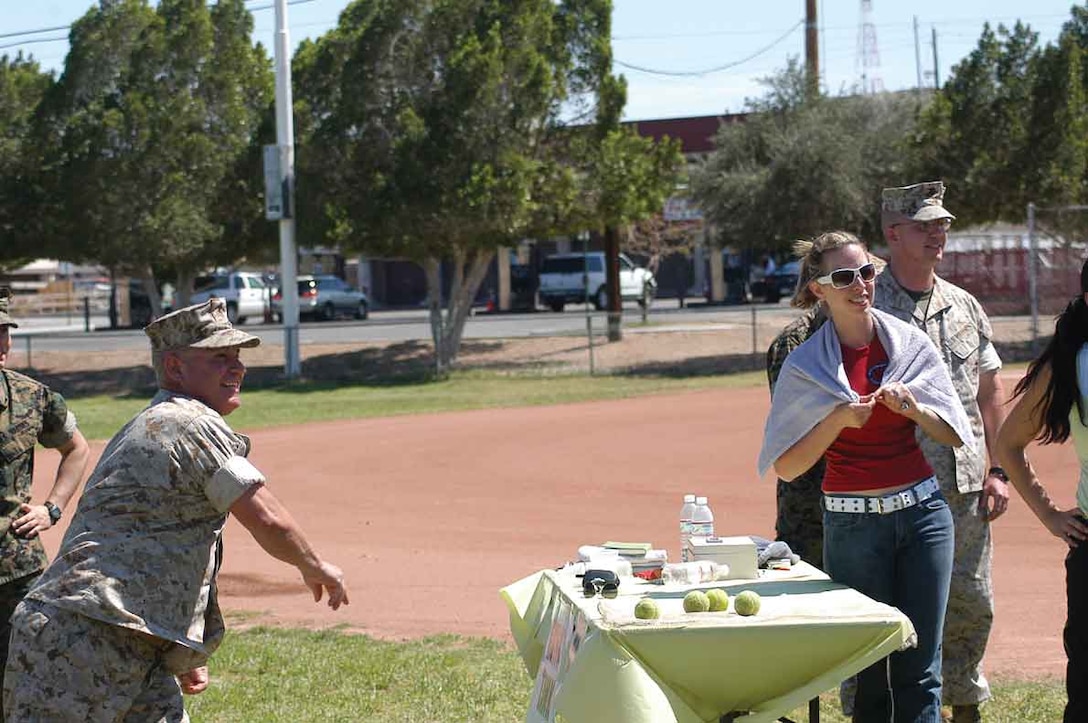 Sgt. Maj. Manuel Garibay Jr., station sergeant major, tries his arm against Sgt. Maj. Robert Bush, Headquarters and Headquarters Squadron sergeant major, at the Single Marine and Drug Demand Reduction programs ?spring break barbeque at softball field 545 across from the gymnasium here April 7. On his first throw, Garibay broke the target, and on his second, he succeeded in dunking Bush, giving new meaning to the phrase one shot, one kill. The sergeant major dunk tank was, by far, the most popular attraction at the barbeque. Participants paid $1 for three chances to hit the center target releasing their favorite sergeant major into the ice cold water below them. The sergeant major dunk tank, the only thing Marines had to pay for at the barbeque, raised more than $300.