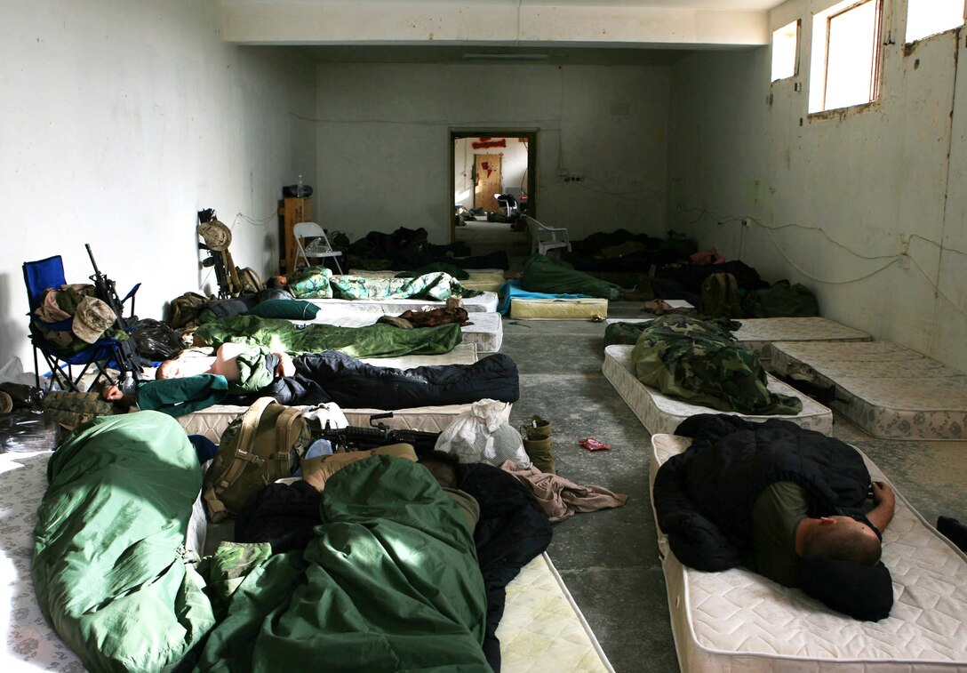 One day before the move, Marines from Headquarters and Support Company sleep on the floor of an old building on Camp Mercury, Iraq April 4.  The Marines of 3rd Battalion, 5th Marine Regiment removed every piece of furniture, wood and electrical wiring from the base before moving to Camp Fallujah April 8, to an area dubbed "South Camp."  The Marines of Headquarters and Support Company now live in four-man air-conditioned rooms and enjoy a wide variety of comforts and amenities afforded on the larger base.