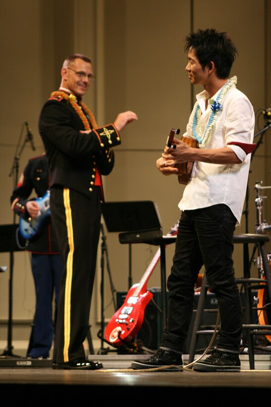 HONOLULU- Jake Shimabukuro, ukulele musician, plays a song with the U.S. Marine Corps Forces, Pacific Band led by Chief Warrant Officer Bryan Sherlock during the Na Mele o na Keiki, 'Music for the Children' Toys for Tots concert at the Neal S. Blaisdell Concert Hall Dec 10.  Shimabukuro was one of five musical performances to play for a near-capacity hall.