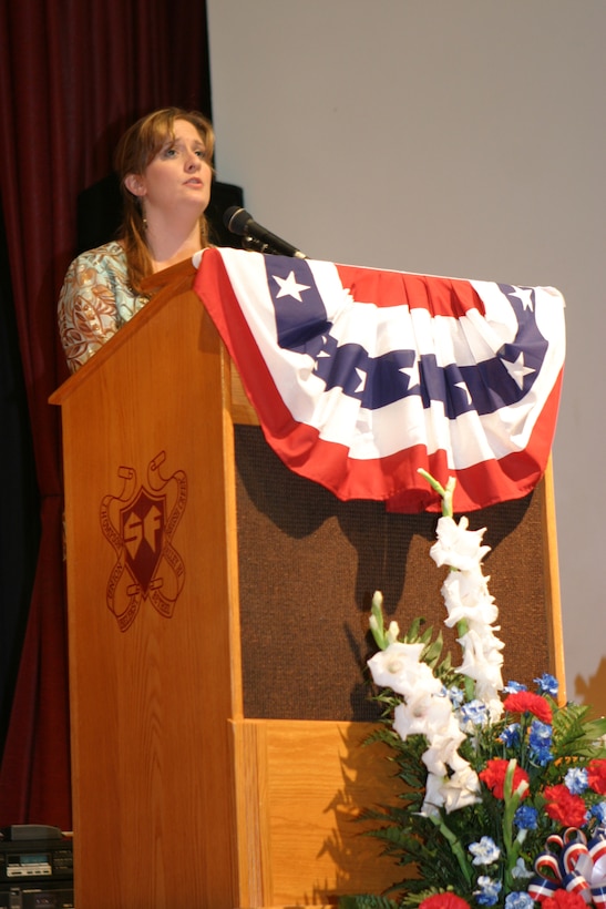 Stephanie Szwydek sings the national anthem at the opening of a memorial service held in honor of her brother, Lance Cpl. Steven W. Szwydek, at South Fulton High School, Warfordsburg, Penn., July 9, 2006.  Following, the service, attended by more than 700 people, a statue on the school's front lawn was dedicated to Szwydek and all other fallen troops.