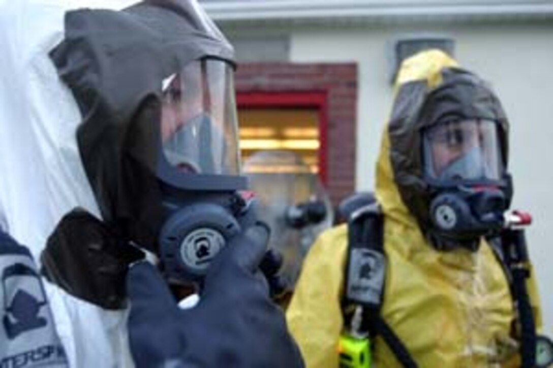 Marines of the 26th Marine Expeditionary Unit's Chemical, Biological, Nuclear and Radiological Defense reaction force make final adjustments to their protective gear as they prepare for a day of training at the enhanced CBRN defense course, Camp Lejeune, N.C., Aug. 9, 2006.