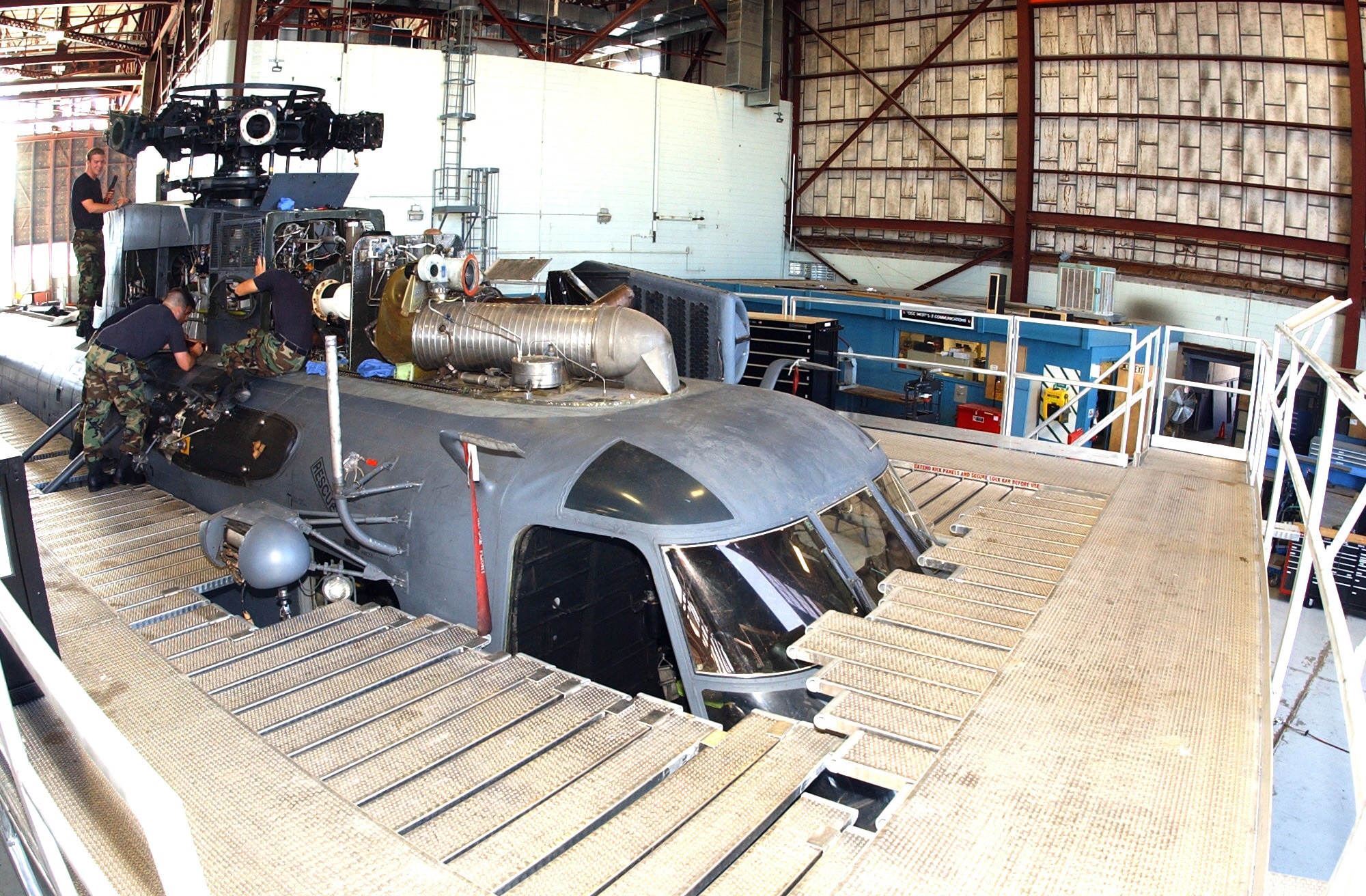 KIRTLAND AIR FORCE BASE, N.M. -- Members of the 58th Maintenance Squadron use a new aircraft stand to work on a MH-53J Pave Low helicopter. The stand allows maintainers to safely work around the entire aircraft and have tool boxes permanently on the upper level. (U.S. Air Force photo by Damian Bohannon)