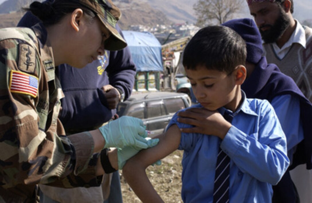 Army Capt. Nanette Gegontoca administers a vaccine to a Pakistani child at the Muslim Public School in Muzaffarabad, Pakistan, on Jan. 7, 2006. The Department of Defense is supporting the State Department by providing disaster relief supplies and services following the massive earthquake that struck Pakistan and parts of India and Afghanistan. Gegontoca is attached the 212th Mobile Army Surgical Hospital. 