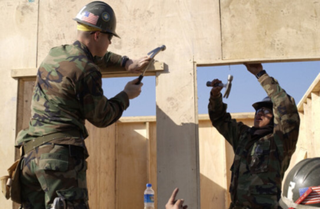 Seabees nail some trim pieces in place as they construct a plywood Southeast Asia Hut to serve as a temporary structure for the damaged Ministry of Education Post Graduate Men's College in Muzaffarabad, Pakistan, on Jan. 6, 2006. The Department of Defense is supporting the State Department by providing disaster relief supplies and services following the massive earthquake that struck Pakistan and parts of India and Afghanistan. The Seabees are attached to Naval Mobile Construction Battalion 74, deployed from Gulfport, Miss. 