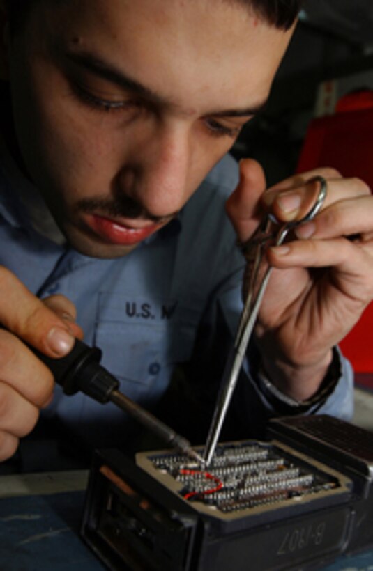 Petty Officer 3rd Class Stephen Hanna performs corrective maintenance on a portable radio communicator aboard the aircraft carrier USS Theodore Roosevelt (CVN 71) while the ship operates in the Persian Gulf on Jan. 7, 2006. Hanna is a Navy electronics technician aboard the aircraft carrier. Roosevelt and its embarked Carrier Air Wing 8 are conducting maritime security operations in the Persian Gulf. 