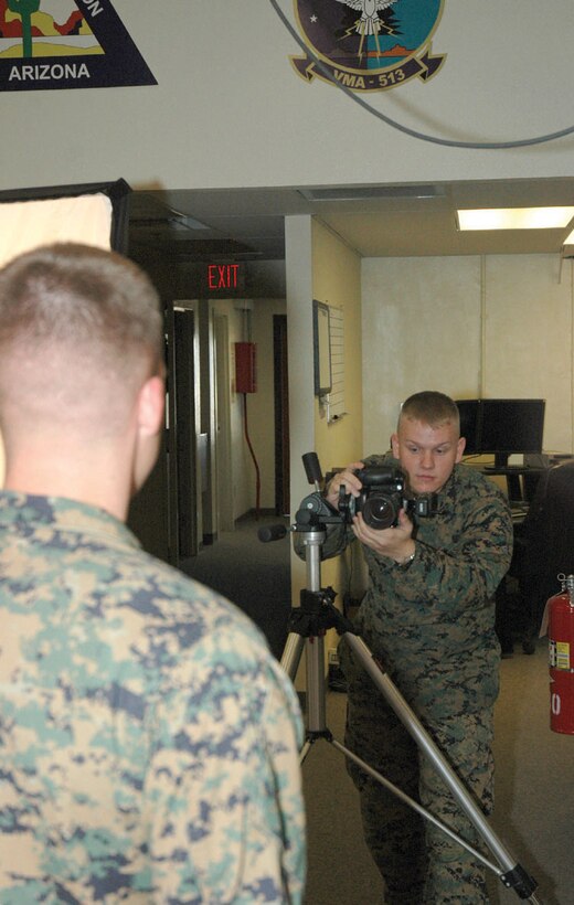 Lance Cpl. Cory Tepfenhart, Headquarters and Headquarters Squadron combat photographer and native of Wiliston, Fla., prepares to take a studio portrait of Sgt. Vincent Czyzewski, H&HS combat videographer and native of Sarasota, Fla., Monday at station Combat Camera. Combat Camera provides the station with a multitude of services, ranging from promotion board photos to mass-produced pamphlets for briefings.