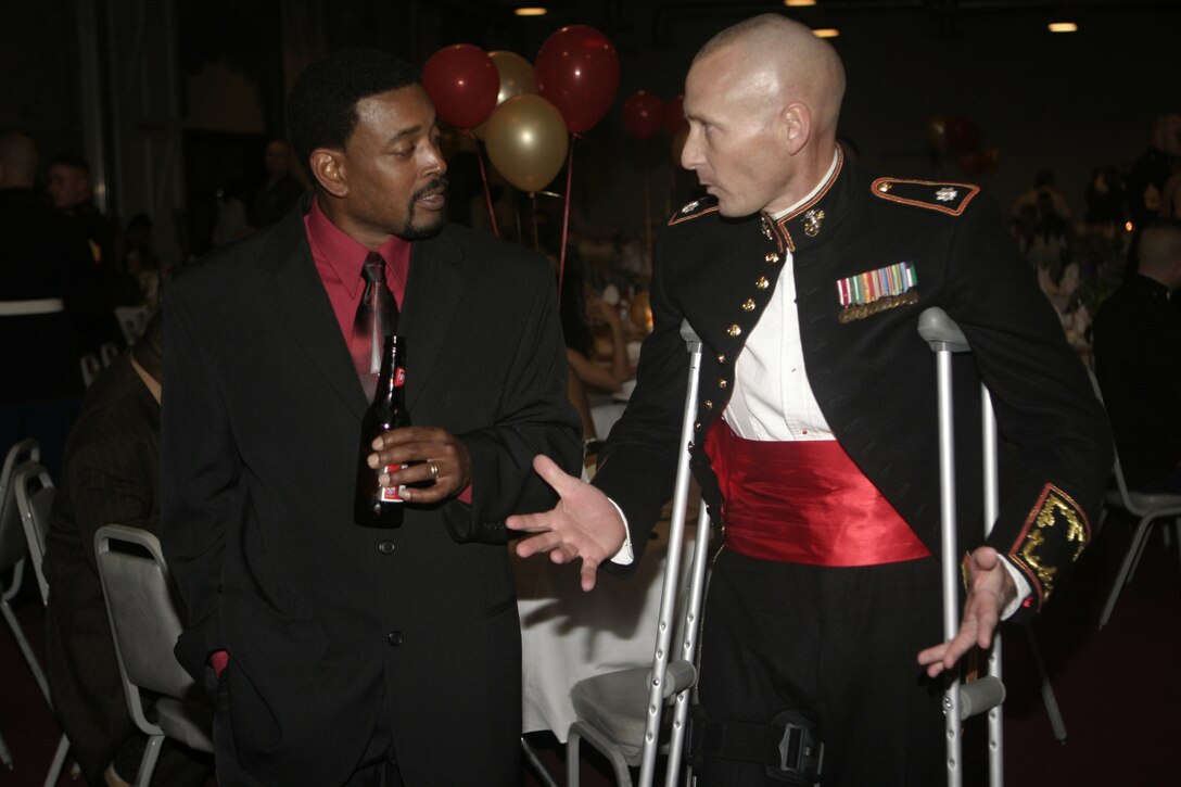 WILMINGTON, N.C. - Lt. Col. Michael L. Kuhn, 2nd Assault Amphibian Battalion's commanding officer, speaks with a retired Marine formerly with the same unit inside the Coastline Convention Center here March 10.  The 2nd AA Battalion and several retired Marines were celebrating their unit's 64th anniversary with a formal night of dinner and dancing.