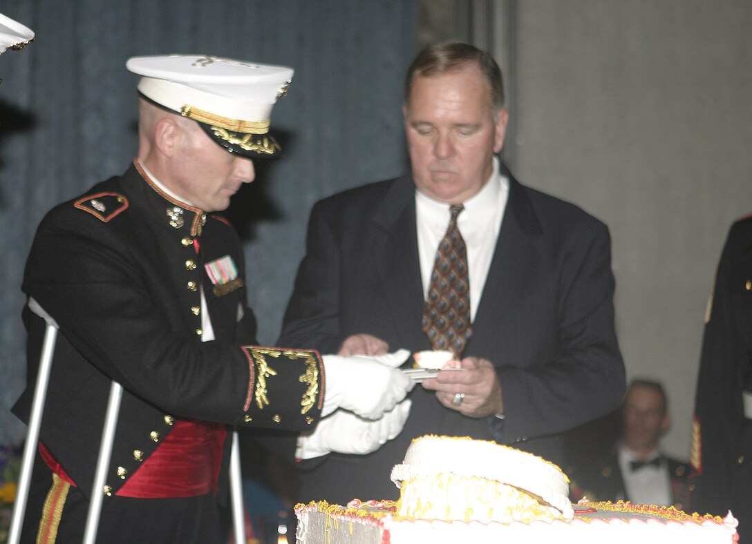 WILMINGTON, N.C. - Col. Kenneth Priestly, a retired Marine and formerly 2nd Assault Amphibian Battalion's commanding officer, receives the first slice of the unit's birthday cake from Lt. Col. Michael L. Kuhn, 2nd Assault Amphibian Battalion's commanding officer, inside the Coastline Convention Center here March 10.  The 2nd AA Battalion and several retired Marines were celebrating their unit's 64th anniversary with a formal night of dinner and dancing.