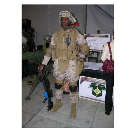 Sgt. Alexander Wesley, an instructor at The Basic School on Marine Corps Base Quantico, exhibits the full combat load including a prototype of the Modular Tactical Vest (MTV), in Marine Corps Systems Command?s Static Display Tent at the dedication of the National Museum of the Marine Corps on Nov. 10.