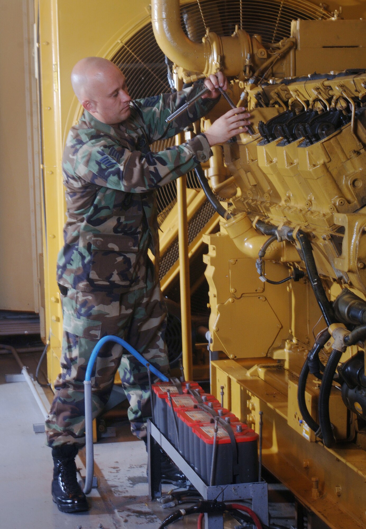 ANDERSEN AIR FORCE BASE, Guam (AFPN) -- Staff Sgt. Keith Ongley installs a valve cover on a 1,000-megawatt generator during an inspection at his facility here. Sergeant Ongley is an electrical power production craftsman with the 36th Civil Engineer Squadron. The 36th CES Airmen support the Detachment 5, 22nd Space Operations Squadron mission here. (U.S. Air Force photo by Master Sgt. Val Gempis)