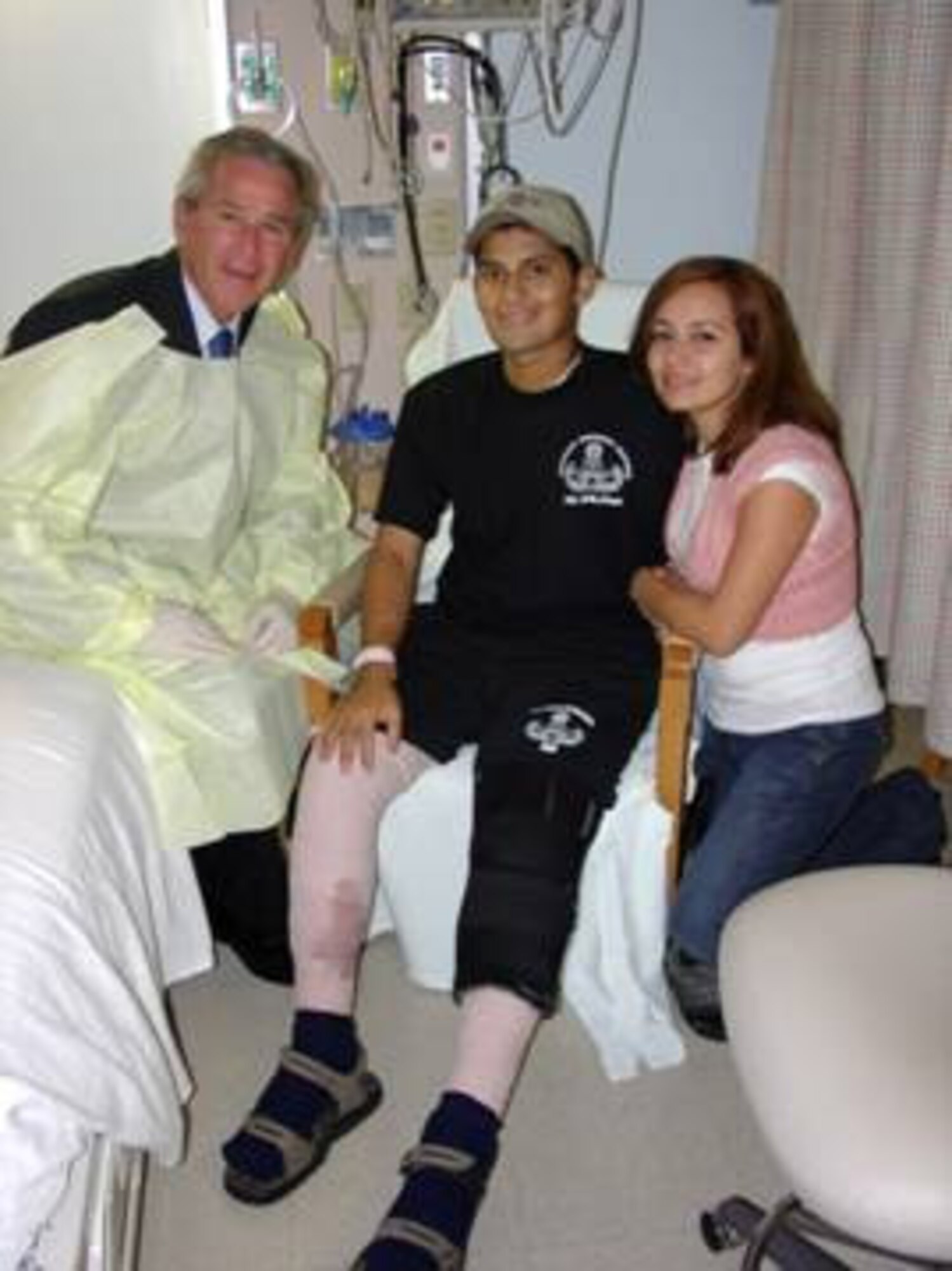 President George W. Bush visits with Airman Daniel Acosta and his wife, Sandy Jan. 1 at the Brooks Army Medical Center, Texas where he is being treated for injuries sustained while serving in Iraq. (Courtesy photo)