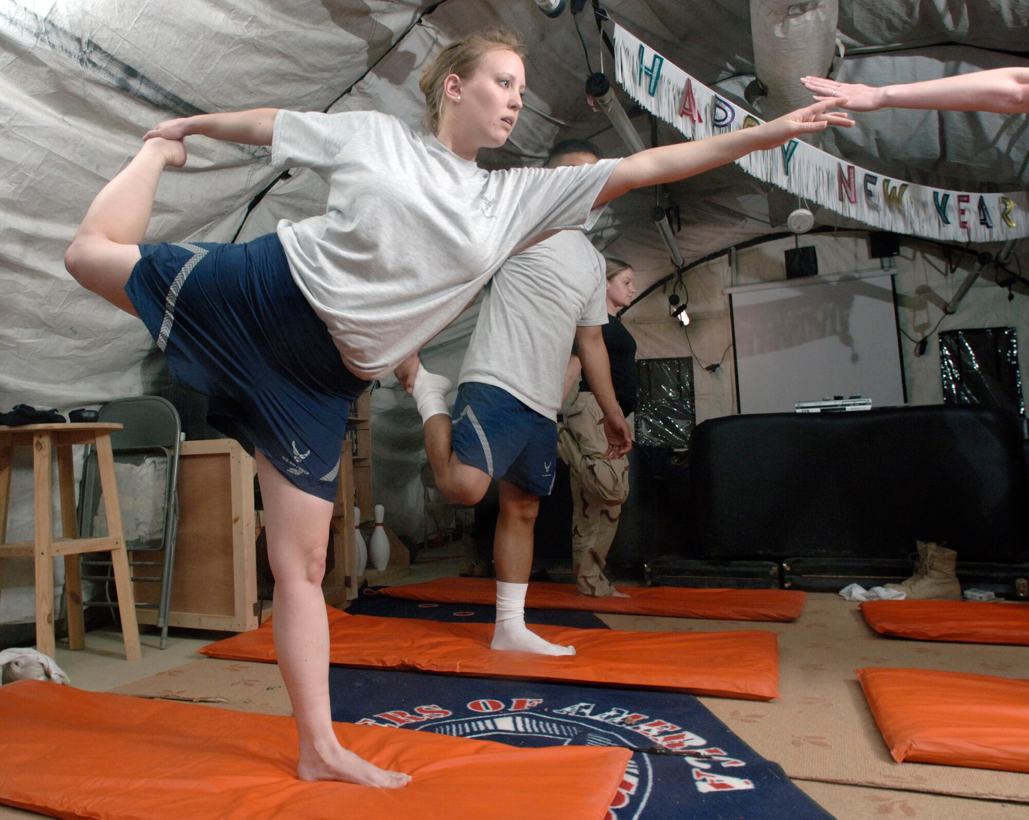 BALAD AIR BASE, Iraq (AFPN) -- Staff Sgt. Bonnie McKinley leads a yoga class during a break in her 15-hour shift at the Air Force Theater Hospital here. The 5-foot-4-inch respiratory therapist with the 332 Expeditionary Medical Group weighs 140 pounds. But, a few years ago, she weighed 215 pounds after a pregnancy. She attributes her weight loss and fitness increase to the practice of yoga and a healthy diet. She is deployed from Sheppard Air Force Base, Texas. (U.S. Air Force photo by Master Sgt. Lance Cheung)