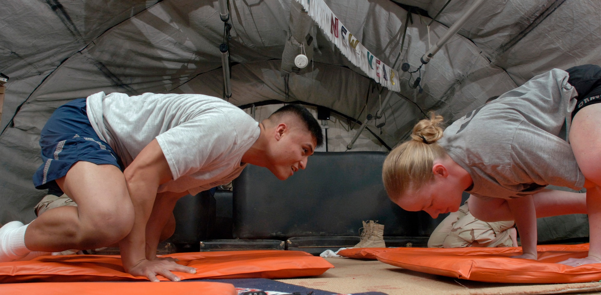BALAD AIR BASE, Iraq (AFPN) -- Staff Sgt. Joseph Jalkennen and Army Capt. Amy Hadsall practice one of several challenging yoga postures during a class held at the Air Force Theater Hospital here. (U.S. Air Force photo by Master Sgt. Lance Cheung)
