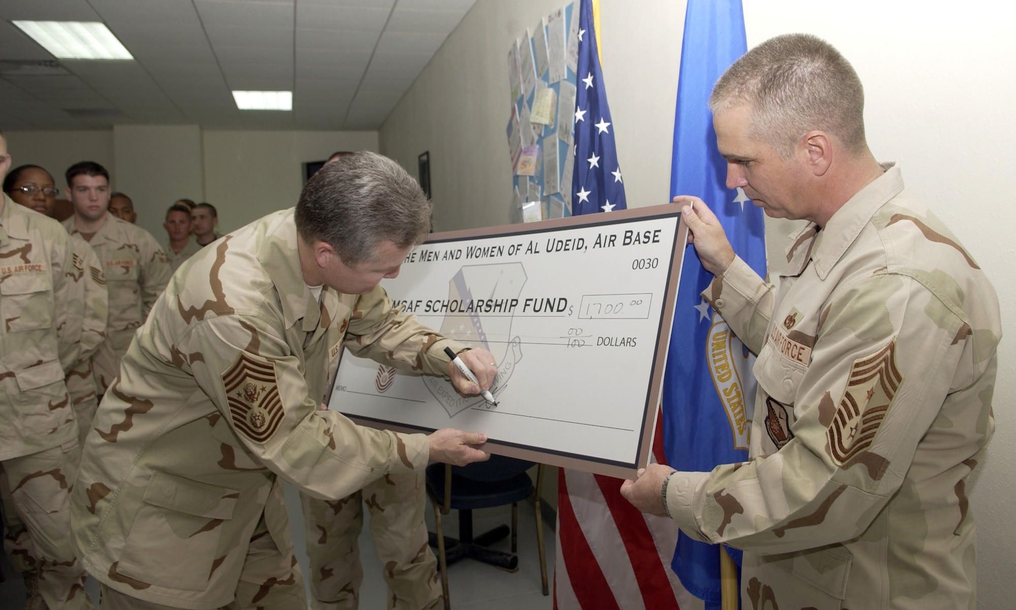 SOUTHWEST ASIA (AFPN) -- Chief Master Sgt. of the Air Force Gerald R. Murray accepts a check on behalf of the 379th Air Expeditionary Wing, Jan. 3.  The check is in amount of $1,700 for the CMSAF Scholarship Fund.  (U.S. Air Force photo by Staff Sgt. Rhiannon Willard) 