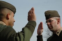 ARLINGTON, Va. - Chief Warrant Officer 3 Ramon Perez administers the oath of reenlistment to Sgt. Robert A. Kelm at Arlington National Cemetery Feb. 10.  Kelm originally joined the Marine Corps in 1999 to carry on the family tradition that his grandfather, Army 1st Lt. Arthur W. Kelm started by serving during WW II.