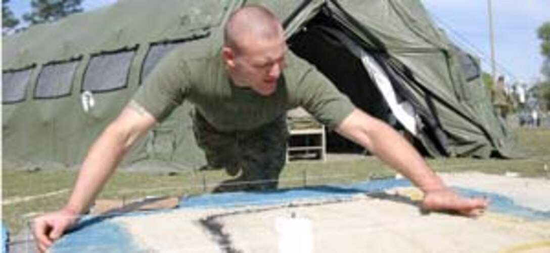 Staff Sergeant Matthew M. Quinton, 26th MEU chemical, biological, radiological and nuclear chief, works on a sand table during a command post exercise aboard Camp Lejeune, N.C., April 11.