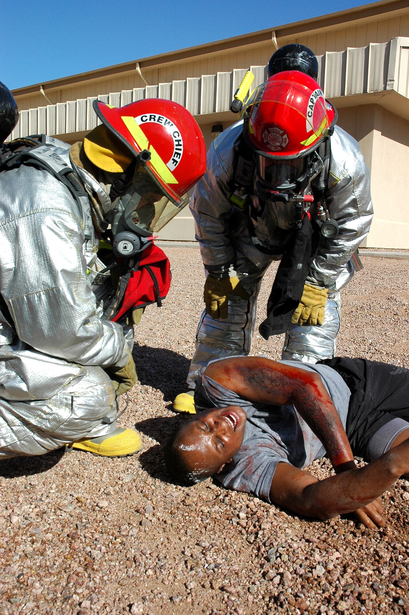 DAVIS-MONTHAN AIR FORCE BASE, Ariz. (AFPN) -- Staff Sgt. Stephen Leatherman (left) and Jeff Somers help a "wounded" Master Sgt. Norvell Harris during an accident response exercise here. Sergeant Leatherman and Mr. Somers are with the 355th Civil Engineer Squadron. Sergeant Harris is with the 355th Logistics Readiness Squadron. (U. S. Air Force photo by Airman 1st Class Clark Staehle)