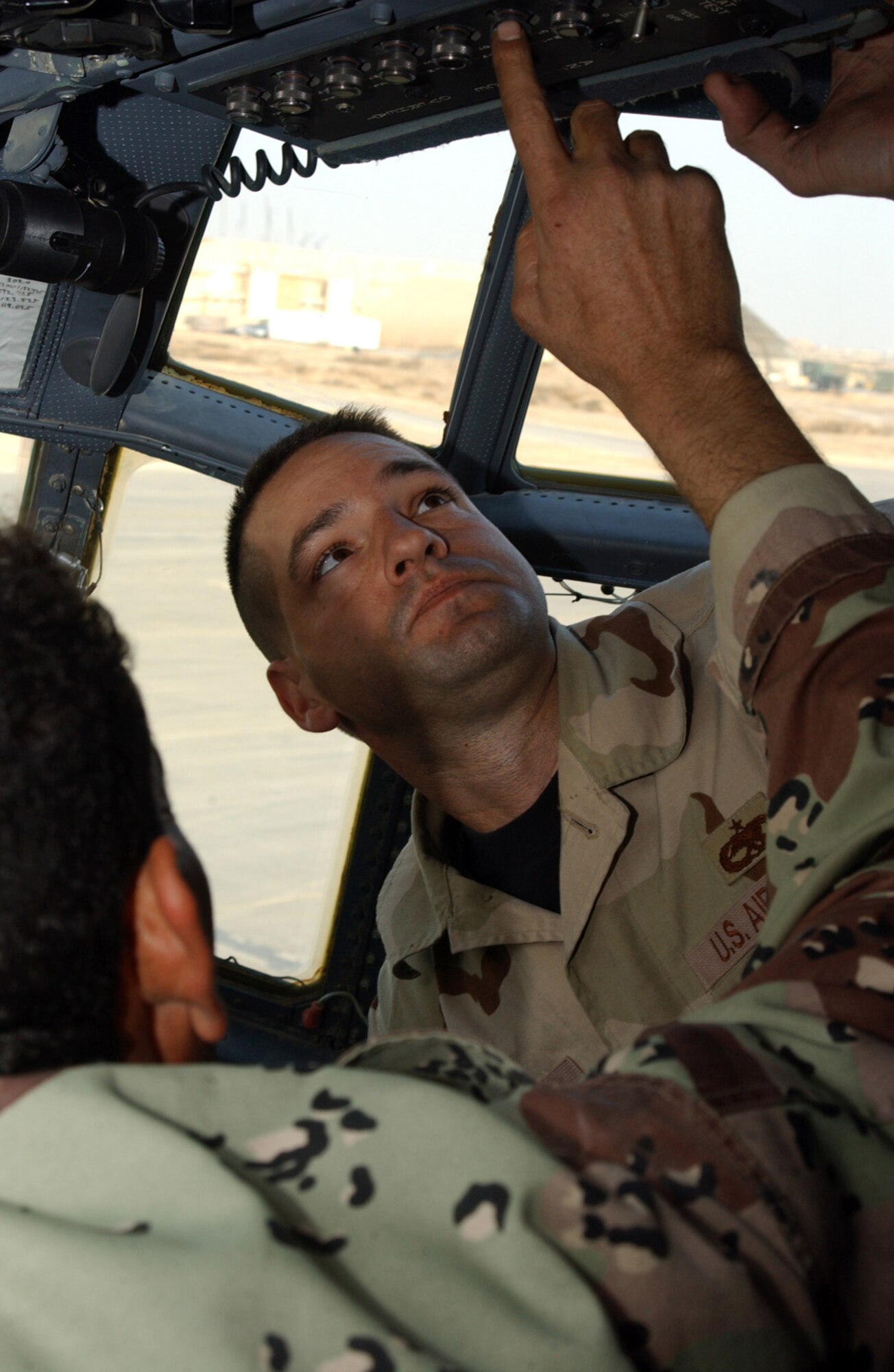 ALI BASE, Iraq (AFPN) -- Tech. Sgt. Charles Francks, helps one of his propulsion students. They are checking cockpit indicators and switches related to engine information and operation. Sergeant Franks has four students in his engine section. Advisory support team instructors of the 777th Expeditionary Airlift Squadron are scheduled to relocate to the new home of the Iraqi Air Force Squadron 23 (Transport) at New Al Muthana Air Base, Baghdad International Airport within the next few weeks. Sergeant Francks is deployed from the 86th Maintenance Squadron at Ramstein Air Base, Germany. (U.S. Air Force photo by Tech. Sgt. Paul Dean)