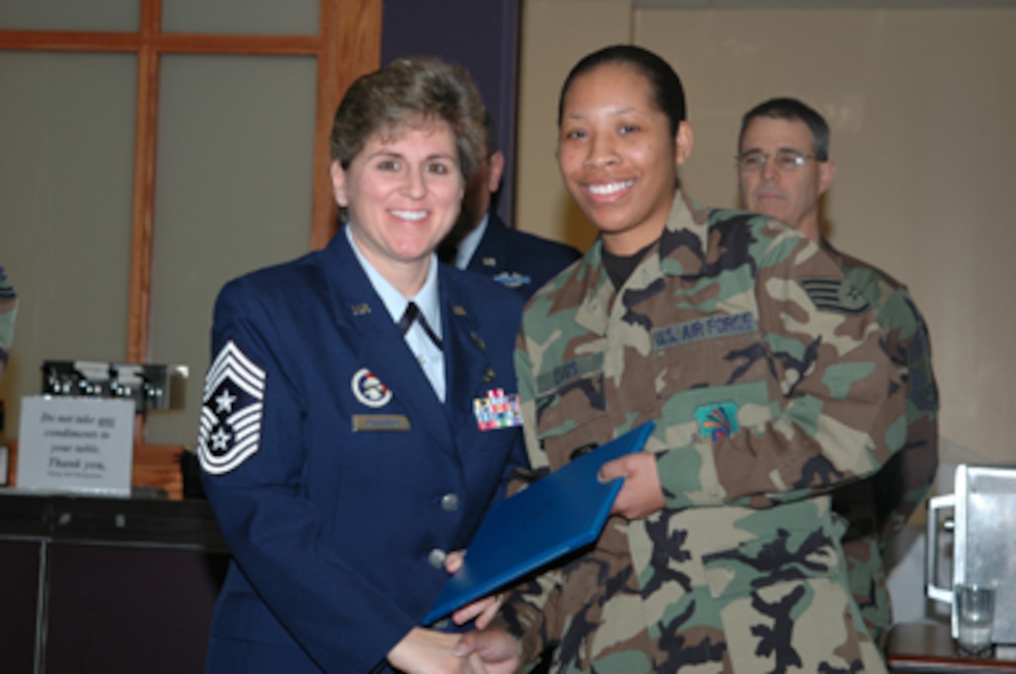 Grissom Air Reserve Base, Ind -- Chief Master Sgt. Peri Rogowski, 434th Air Refueling Wing's Command Chief, inducts Staff Sgt. Kelly Davis, 434th Mission Support Flight, into the fraternity of noncommissioned officers during a special induction ceremony. The quarterly ceremony recognizes new NCOs and new senior NCOs.   The 434th Air Refueling Wing is an Air Force Reserve Command unit located at Grissom ARB, Ind. (Photo by SrA. Jonathan Jones)