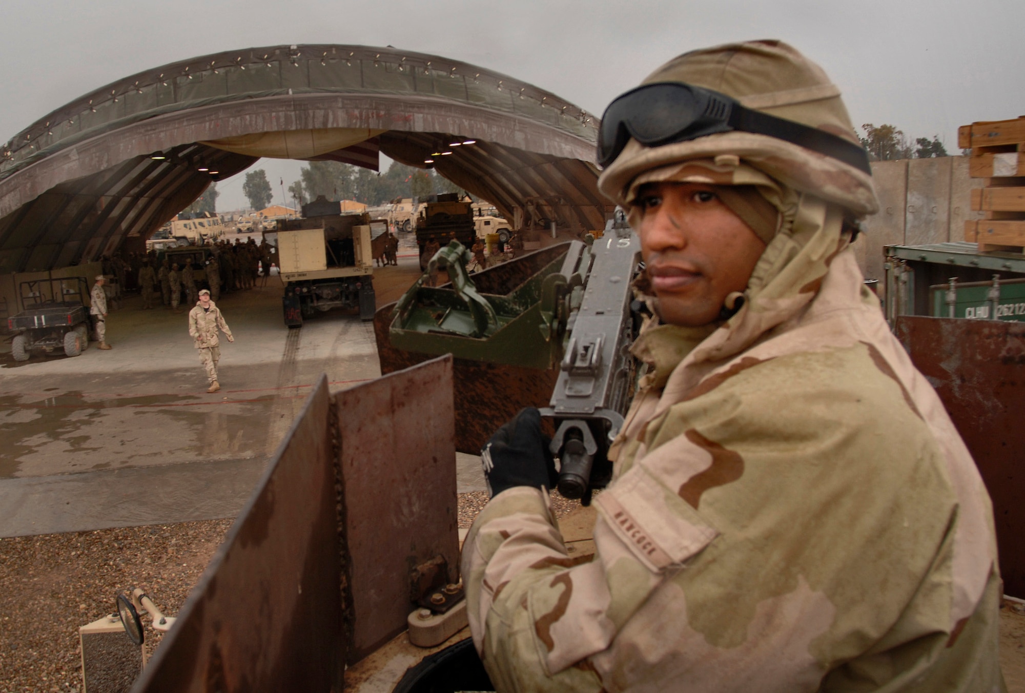 BALAD AIR BASE, Iraq (AFPN) -- Staff Sgt. Viktor Hancock checks the area behind an armor-modified vehicle as he heads to debrief with other Airmen. The Airmen celebrated their return from a convoy security mission that made the 4-million mile mark. Sergeant Hancock is a gunner with the 732nd Expeditionary Logistics Readiness Squadron and is deployed from Nellis Air Force Base, Nev. (U.S. Air Force photo by Master Sgt. Lance Cheung) 