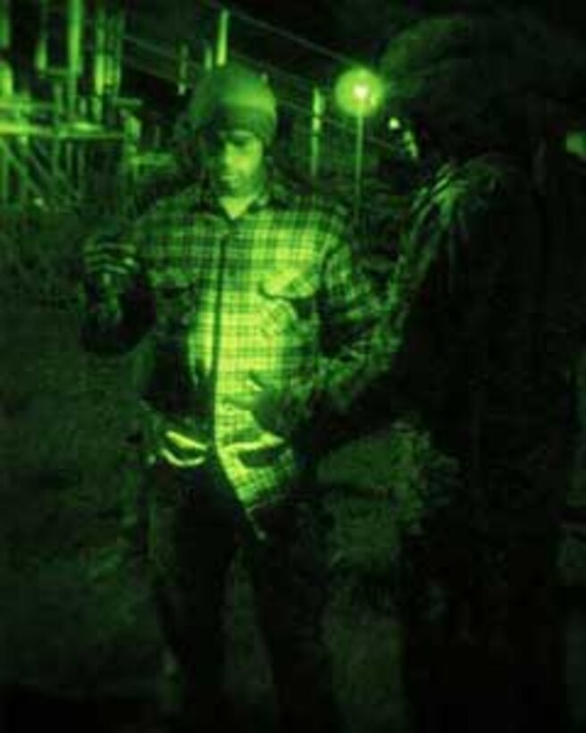 CAMP PENDLETON, Calif. (Apr. 11, 2006) --    A Marine from 5th Battalion 11th Marine Regiment screens an evacuee during the processing portion of a Non-combatant Evacuation Operation Exercise at 52 area Combat Town here. Marines from 5/11 were tasked with providing security and processing of the non-combatants during the NEO Exercise in support of the 15th Marine Expeditionary Unit during its MEUEX. MEUEX is a series of exercises designed to prepare the 15th MEU for its planned deployment this fall.