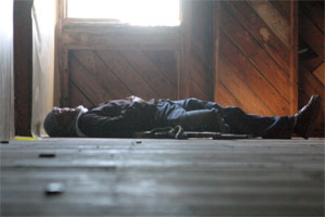 A role player acting as an insurgent lies ?dead? on the floor of a target building after Marines with Bravo Company, Battalion Landing Team 1st Bn., 8th Marine Regiment, 24th Marine Expeditionary Unit, raided the revamped Combat Town April 11.  The training took place aboard Marine Corps Base Camp Lejeune, N.C., in the newly remodeled Combat Town, designed to replicate an Iraqi village.