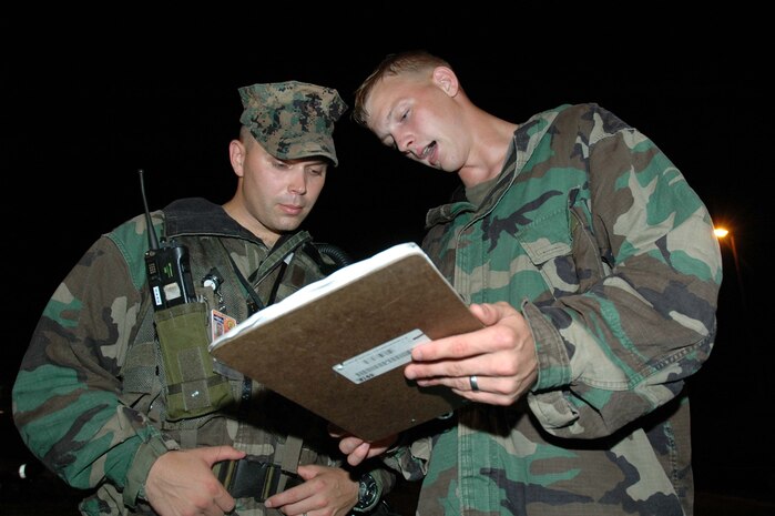 ST. LOUIS--Lance Cpl. Jeffery L. Lemons (right), reconnaissance assistant team leader, Chemical Biological Incident Response Force, II Marine Expeditionary Force, briefs Capt. Roy M. Draa, Bravo Company incident response commander during a simulated chemical attack training evolution here Aug. 11.  Lemons, a 21-year-old Springfield, Ohio, native delivered information with potentially life threatening effects as concise, unquestionable facts.  The unit's overall participation in the exercise is an integral part of its ongoing commitment to support local, state and federal first responders with the decontamination and extraction of casualties in the event of a chemical or biological attack.