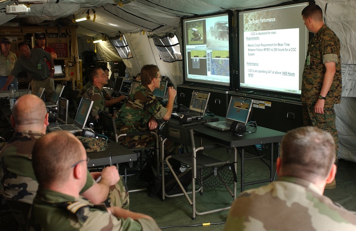 LAGER AULENBACH, Germany ? U.S. Marine Corps Lt. Col. Michael Coolican, Marine Corps Systems Command, explains features of the new combat operation center to French Army representatives during Combined Endeavor 2006 at Baumolder, Germany, May 12, 2006. Combined Endeavor, a U.S. European Command sponsored multinational exercise, representing 41 partner nations, is the largest security cooperation and communications and information system military exercise in the world.