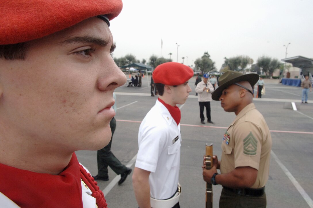 Maintaining his position, a freshly-inspected David Ross ponders the morning while Gunnery Sgt. Luis Atkins finishes inspecting Ryan Vance.