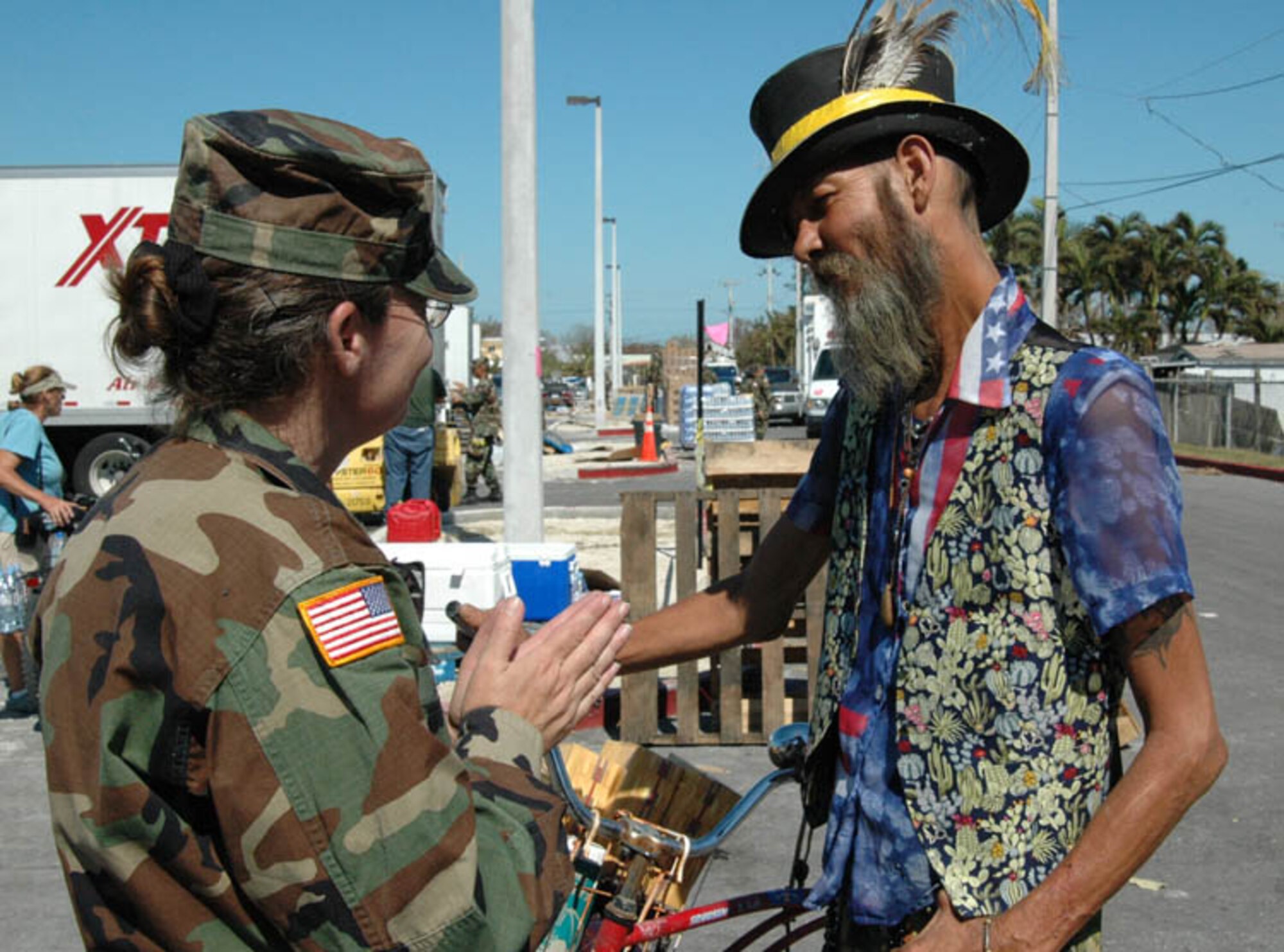 Staff Sgt. Deborah Miale of the Florida Army National Guard's 260th Military Intelligence Battalion (left) talks with Donald Cobert - the self-proclaimed "Wizard of Key West" - at a food and water distribution site in Key West, Oct. 27. (U.S. Air Force photo by Staff Sgt. Thomas Kielbasa.)