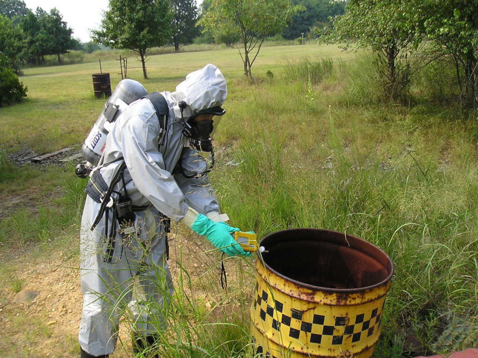 DOVER AIR FORCE BASE, Del. -- Tech. Sgt. Noel Vadell with the 512th Component Maintenance Squadron, an Air Force Reserve Command unit, is a Drug Enforcement Agency forensic chemist who responded to a suspected drug lab site area last year, where drums with hazardous markings were found. He's using an instrument to detect whether or not the drums contained chemical solvents. Sergeant Vadell is a jet engine mechanic in the Air Force Reserve. (U.S. Air Force photo)
