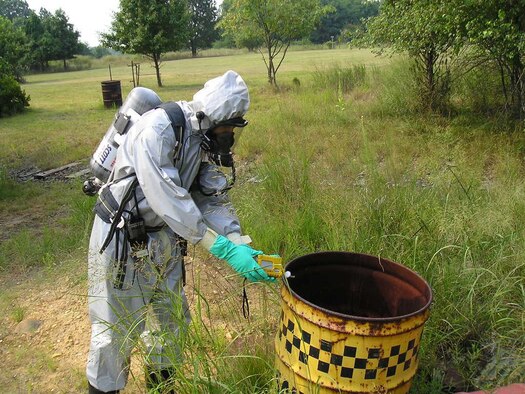 DOVER AIR FORCE BASE, Del. -- Tech. Sgt. Noel Vadell with the 512th Component Maintenance Squadron, an Air Force Reserve Command unit, is a Drug Enforcement Agency forensic chemist who responded to a suspected drug lab site area last year, where drums with hazardous markings were found. He's using an instrument to detect whether or not the drums contained chemical solvents. Sergeant Vadell is a jet engine mechanic in the Air Force Reserve. (U.S. Air Force photo)
