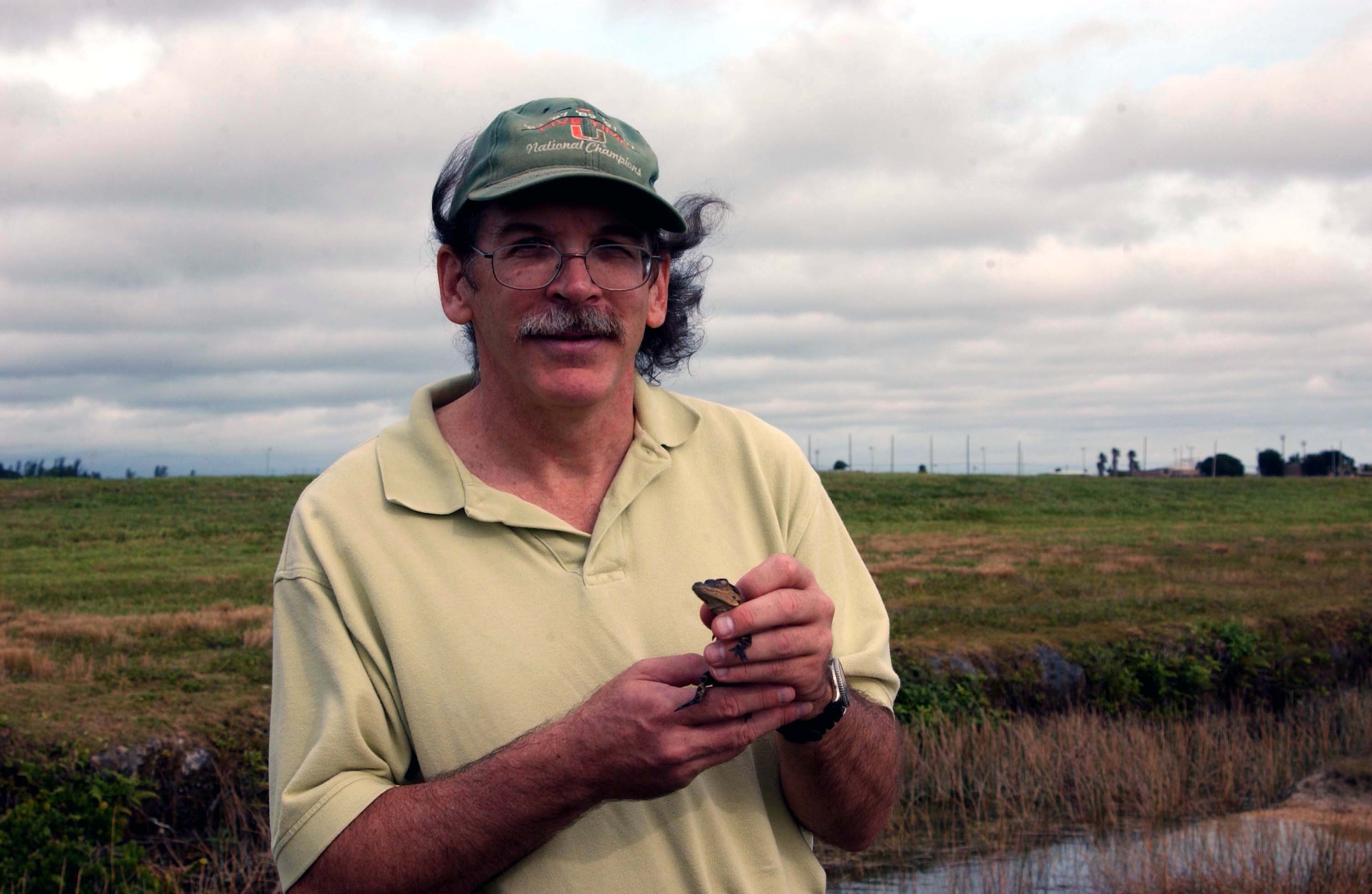 Mike Andrejko, 482nd Environmental Flight, holds a baby alligator that was captured near the flightline at Homestead ARB, Fla.   As part of their duties, members of the environmental office at Homestead ARB help to protect the many different species of wildlife that are found at the base.  The alligator pictured here was released in the Florida Everglades (U.S. Air Force Reserve photo by Lisa Macias). 