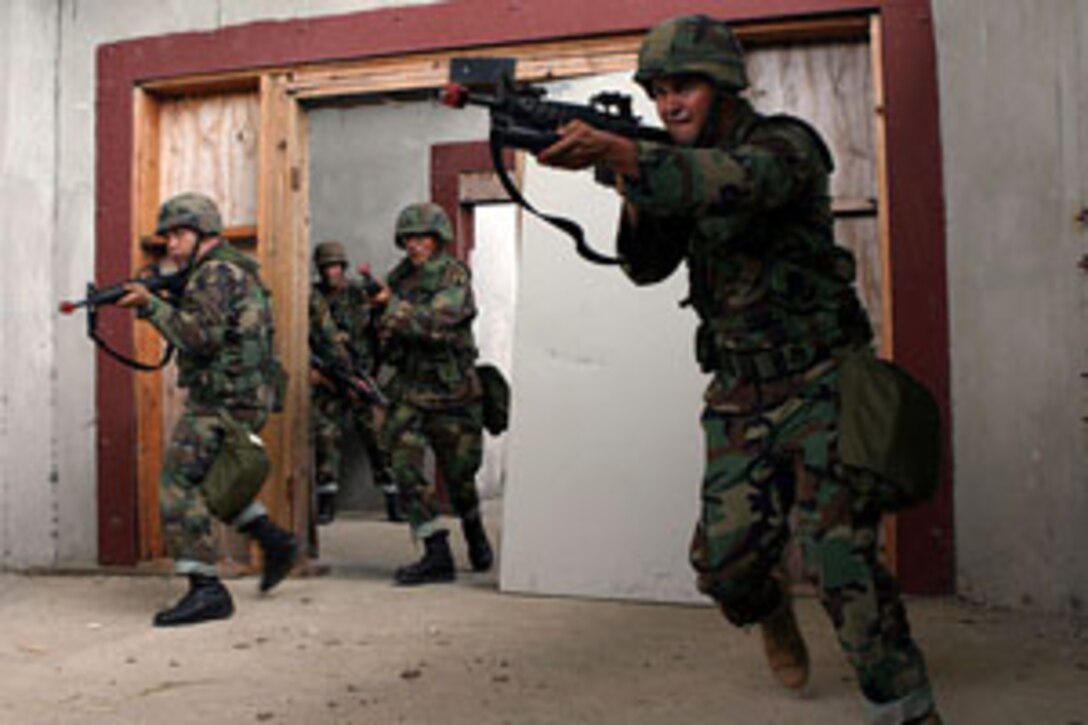 CAMP SANTIAGO, SALINAS, PUERTO RICO ? (July 12, 2006)?Soldiers from the 448th Engineer Battalion and 313th Postal Group, 65th Army Readiness Command of the Army Reserve enter and clear a room during Military Operation Urban Training as taught to them by Team-5 of the Foreign Military Training Unit, Marine Corps Forces Special Operation Command, during their Operational Readiness Exercise here. For their annual training, the soldiers served as students for the team who is preparing to deploy in the upcoming months to South America. (Official U.S. Marine Corps Photo by Cpl. Ken Melton)