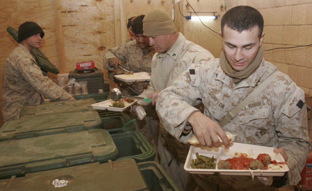 Marines from 1st Light Armored Reconnaissance Battalion, 1st Marine Division, out of Camp Pendleton, Calif., partake in the evening meal prepared by Sgt. Joselito Rubante. Rubante, a 27-year-old Cranford, N.J., native, is a food service specialist with 2nd Marine Logistics Group. He is the lone food preparer at the Joint Border Control Center near Camp Korean Village, Iraq, prearing two meals for 150-300 Marines daily.