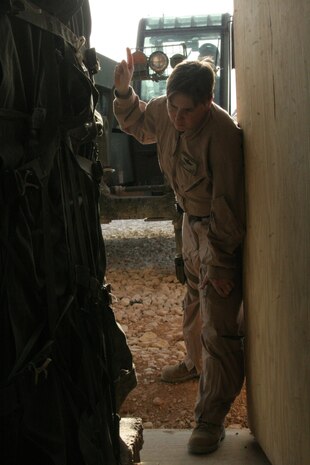Staff Sgt. Christine Weber directs a forklift to pick up a crate for the night's coming air drop at Al Asad, Iraq, April 13. Weber is an assistant air delivery project officer with infantry weapons section, raids and reconnaissance, Marine Corps Systems Command. She is a 30-year-old native of Charlotte, N.C.