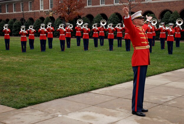 MARINE BARRACKS WASHINGTON ? The director of the Marine Drum and Bugle Corps signals the opposite side of the parade field during Symphony number 9, ?O to Joy.? The musical presentation was part of the Commandant of the Marine Corps passage of command ceremony Nov. 13.