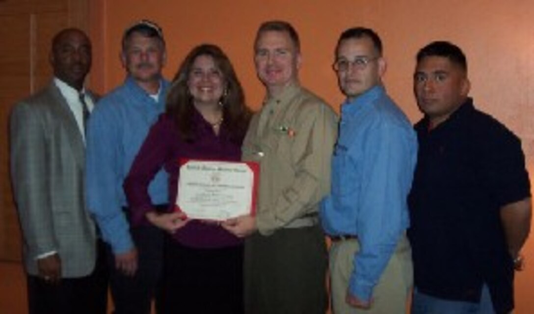 Frances DeSoto (third from left), district human resources manager for AlliedBarton's South Texas district office, receives a certificate of recognition from Marine For Life's San Antonio hometown link, Maj. Matt Stuckey, at the company's district office recently.  Also pictured (from left to right) are transitioned Marines who were hired by AlliedBarton, Gunnery Sgt. Lloyd Baltimore, 1st Sgt. George Erb, Staff Sgt. Guadalupe Ortiz and Lance Cpl. Ramiro Martinez.