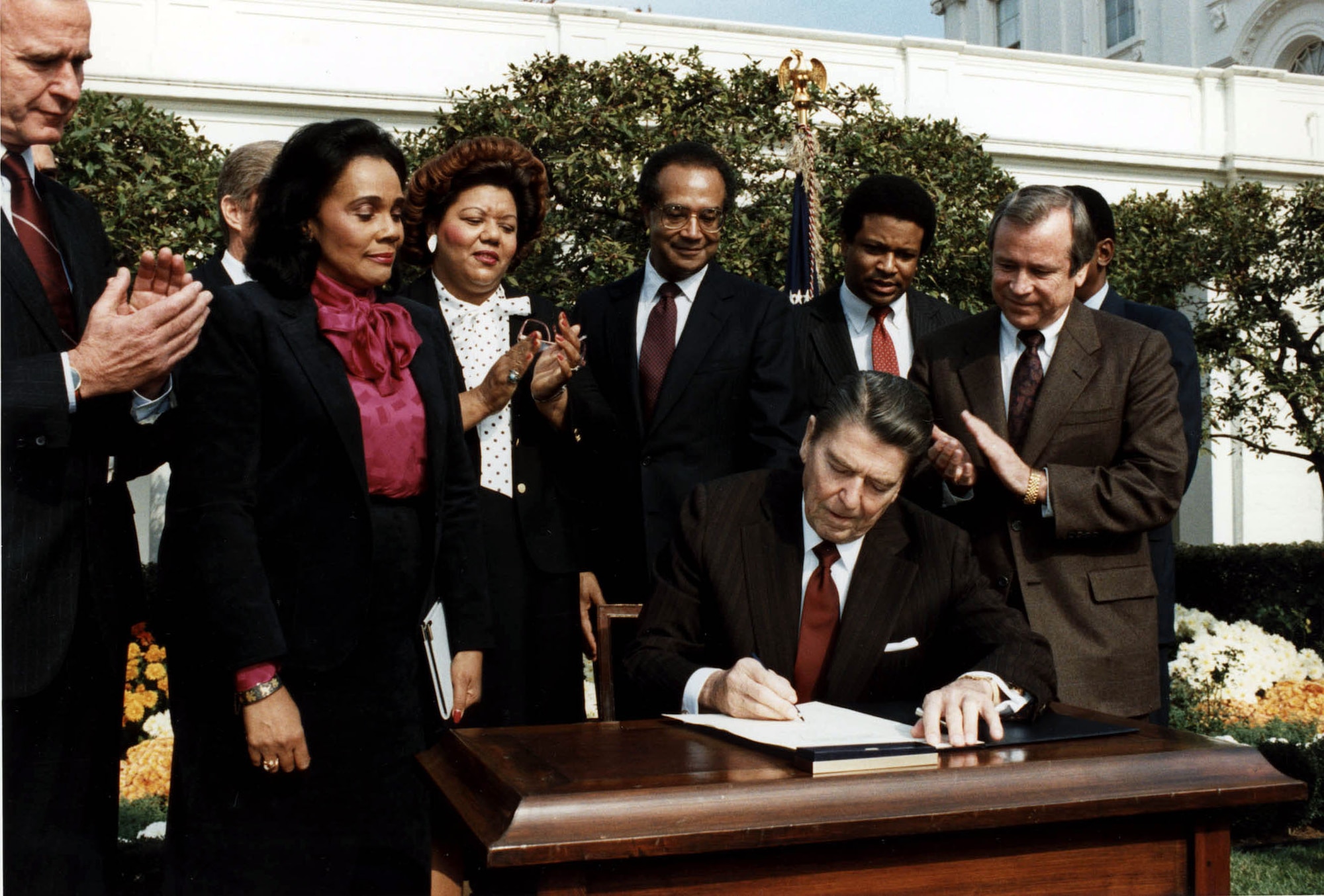 WASHINGTON (AFPN) -- Then-President Ronald Reagan signs the bill commemorating Martin Luther King Jr.'s birthday as a national holiday on Nov. 2, 1983 in the White House rose garden. The first observation was Jan. 20, 1986. This year's observance will mark the 77th birthday of Martin Luther King, Jr. and the twentieth anniversary of the national holiday in his honor. The holiday celebrates the life and legacy of Rev. King who was one of America's leading Civil Rights activists. (Courtesy of the Ronald Reagan Presidential Library)