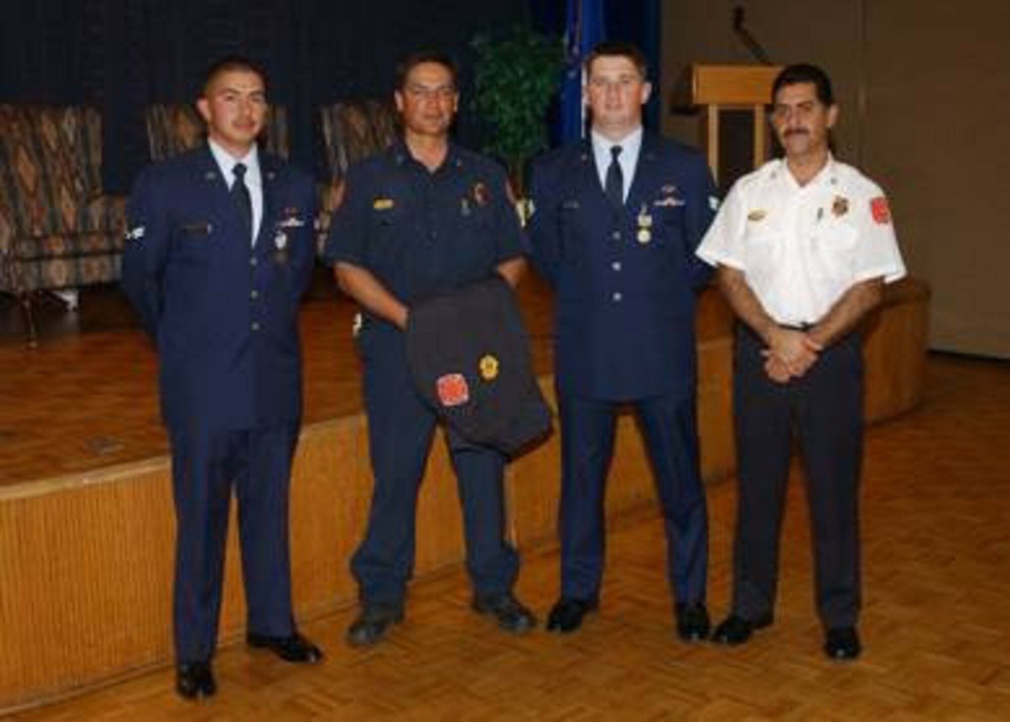 (From left to right) Airman 1st Class Eric Munana, 898th Munitions Squadron; Captain Mark Chavez of the Albuquerque Fire Department; Senior Airman Jonathon Calhoun, 898th Munitions Squadron; and Chief Robert Ortega from the AFD after the medal ceremony where Airmen Calhoun and Munana received Airman's Medals.  The Airmen were given medals after helping Captain Chavez save the lives of a disabled woman and her daughter in an apartment fire in Albuquerque, N.M. (Air Force Photo by Todd Berenger)
