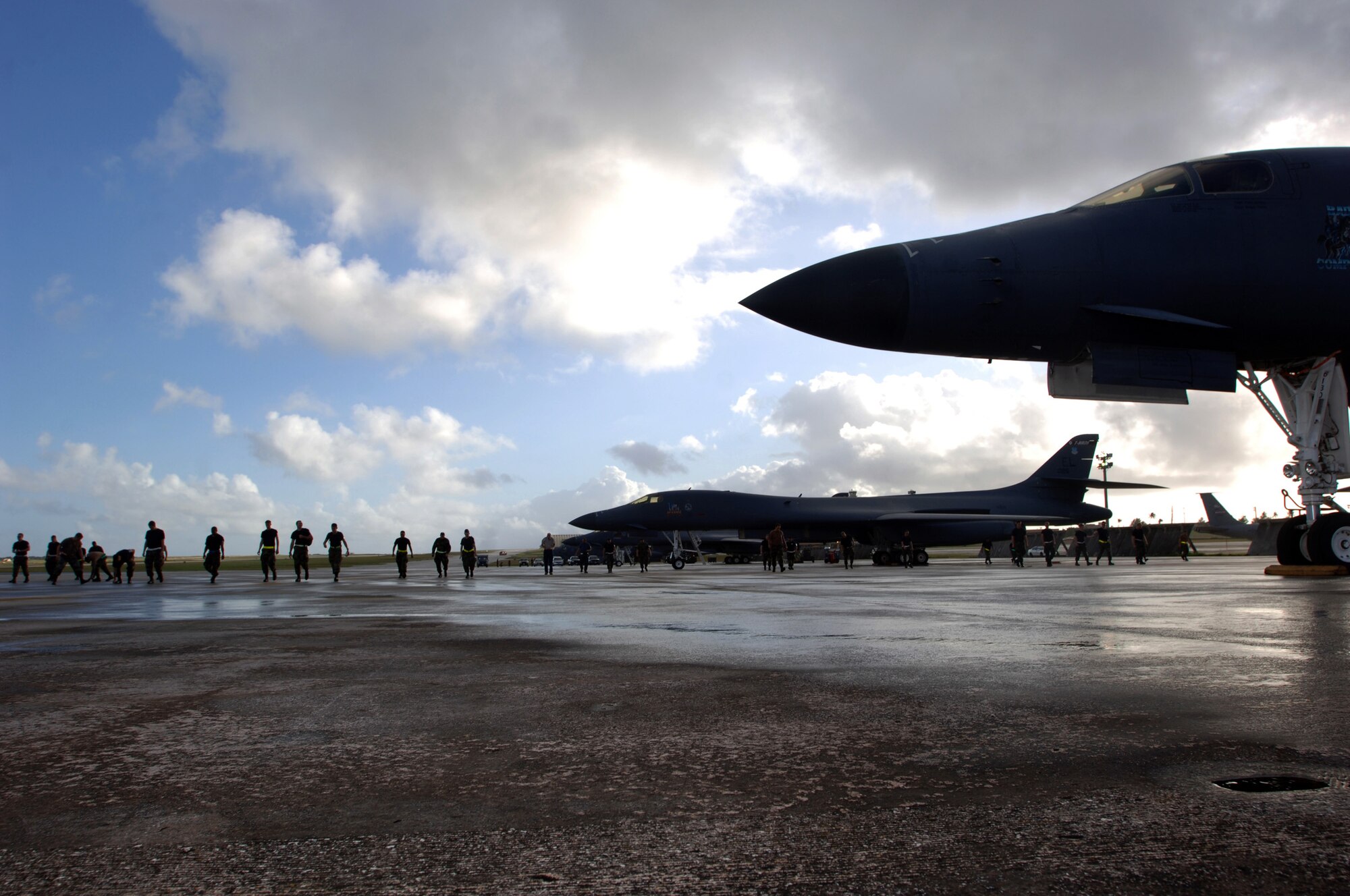 ANDERSEN AIR FORCE BASE, Guam (AFPN) -- Airmen conduct a foreign object damage walk on the flightline before a morning sortie here. The Airmen, from the 28th Bomb Wing at Ellsworth Air Force Base, S.D., are here for an air expeditionary deployment. They provide the U.S. Pacific Command a continuous bomber presence in the Asia-Pacific region. (U.S. Air Force photo by Master Sgt. Val Gempis)