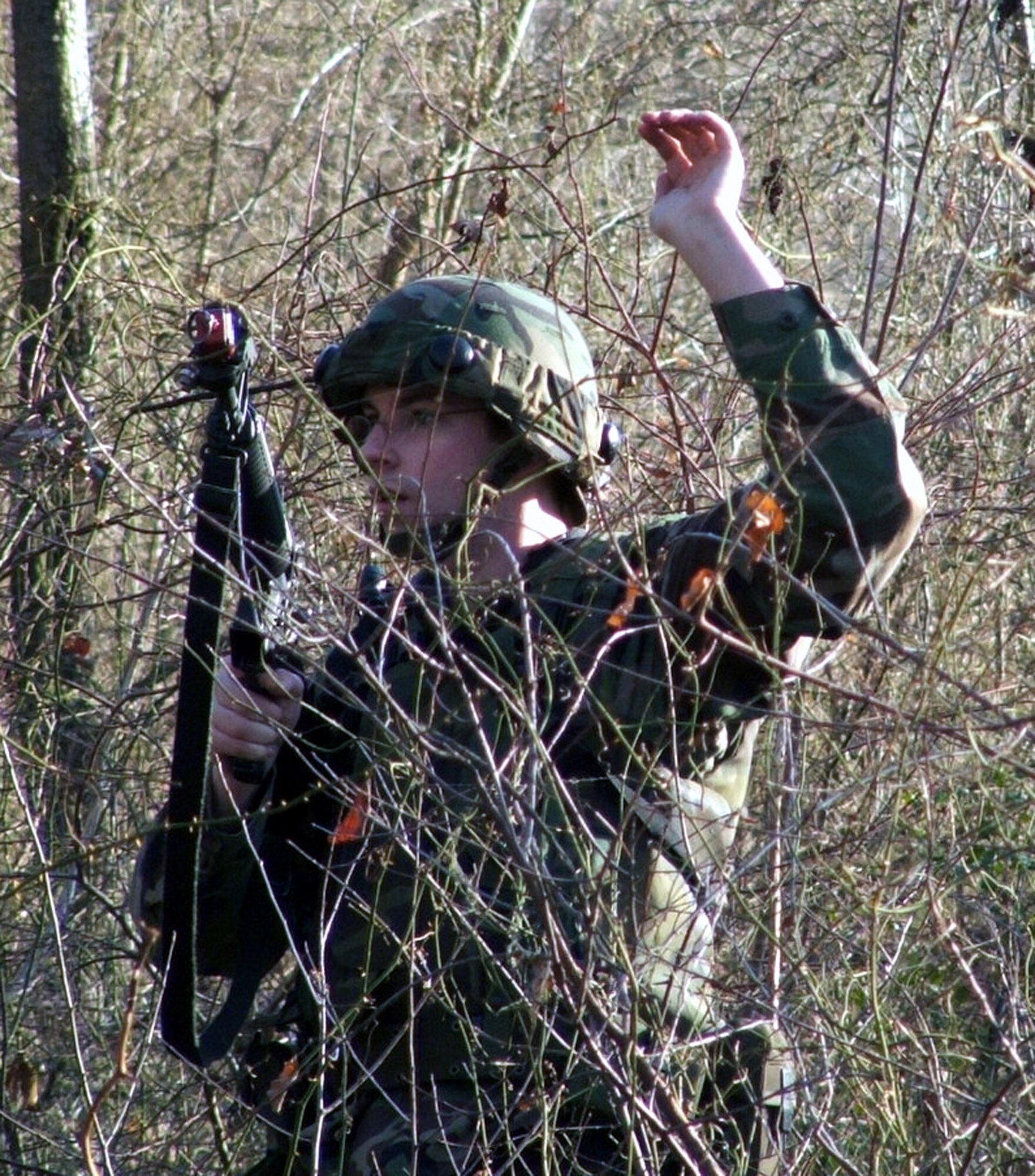 FORT DIX, N.J. (AFPN) -- An Airman signals to his squad during a combat patrol and tactics training session Jan. 12. More than 100 students from multiple career fields participate in the Air Force Integrated Contingency Skills Training Course. In the course, Airmen learn everything from combat tactics and patrolling to convoy operations and combat first aid. The course is directed and taught by the Air Mobility Warfare Center's 421st Combat Training Squadron. (U.S. Air Force photo by Tech. Sgt. Scott T. Sturkol)
