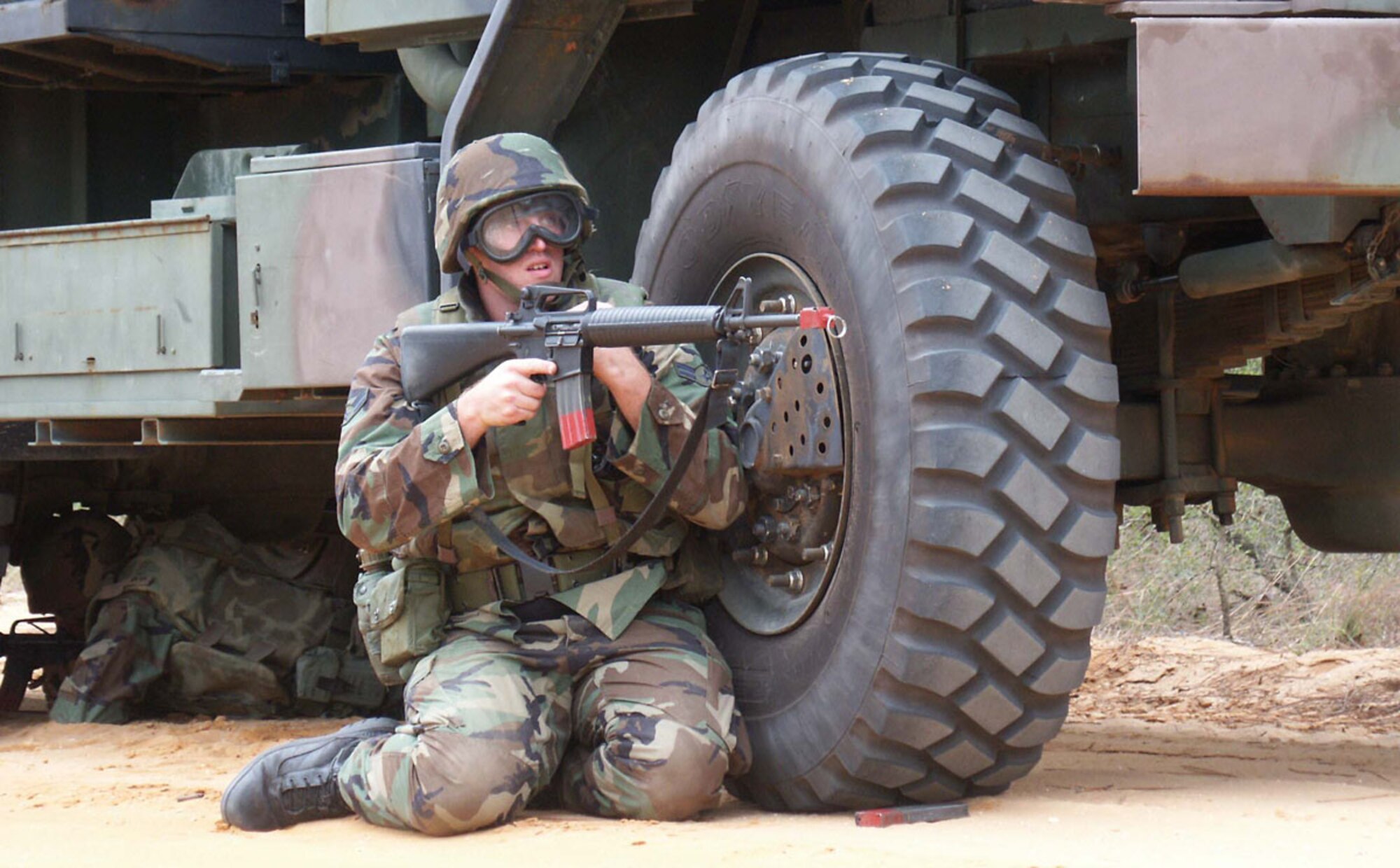 EGLIN AIR FORCE BASE, Fla. (ACCNS) -- Airman 1st Class Brent Hotsinpiller, 728th Air Control Squadron satellite communications specialist, takes cover behind the wheel of a 5-ton truck. Airman Hotsinpiller was defending his convoy from attack during the squadron’s convoy training here Oct. 13. (U.S. Air Force by Staff Sgt. Robert Zoellner)