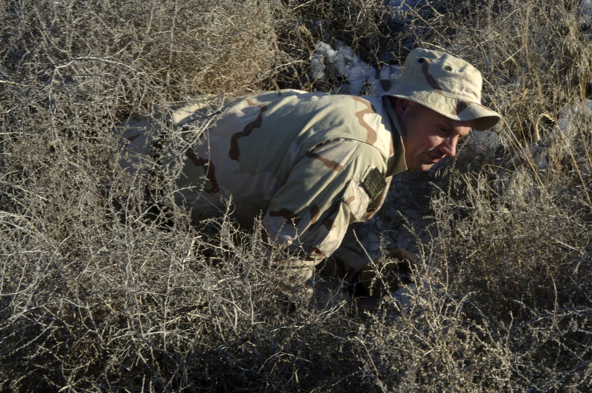 MOUNTAIN HOME AIR FORCE BASE, Idaho (AFPN) -- With a little help from his natural surroundings, Tech. Sgt. Micheal Ferguson, a survival evasion resistance escape specialist here, demonstrates that adequately blending in with your surroundings includes using more than just war paint. Sergeant Ferguson teaches similar techniques that Airmen can use to survive in most any environment, evade and resist capture by the enemy, and escape should they be captured. (U.S. Air Force photo by Staff Sgt. Kathy Parker)