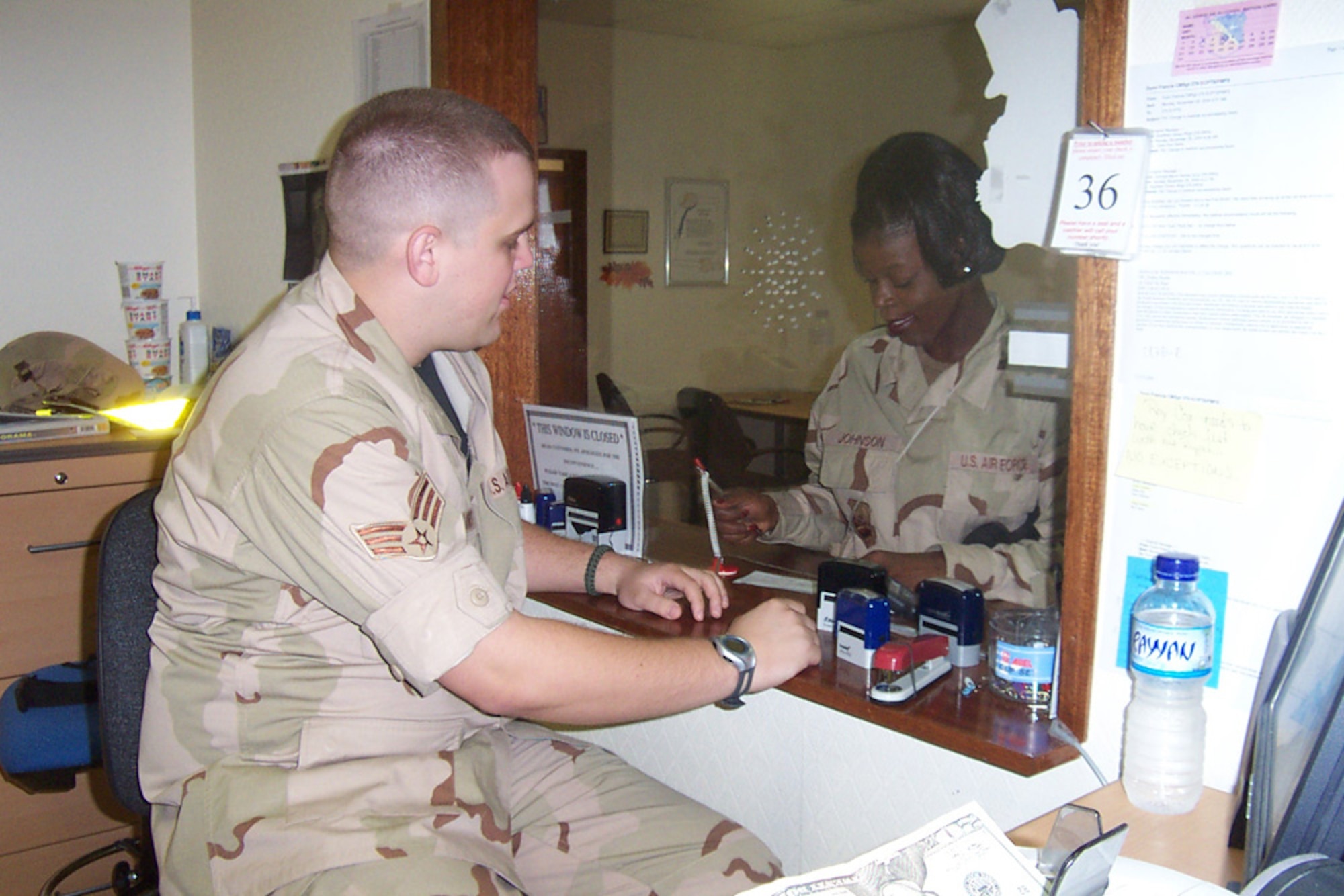 SOUTHWEST ASIA-Senior Airman Mike Hollows, a financial management technician with Air Force Reserve Command's 910th Airlift Wing, exchanges currency for an Airman at the 379th AEW Finance Office.  Hollows is deployed in support of Operation Iraqi Freedom.  U.S. Air Force photo by Capt. Brent J. Davis.