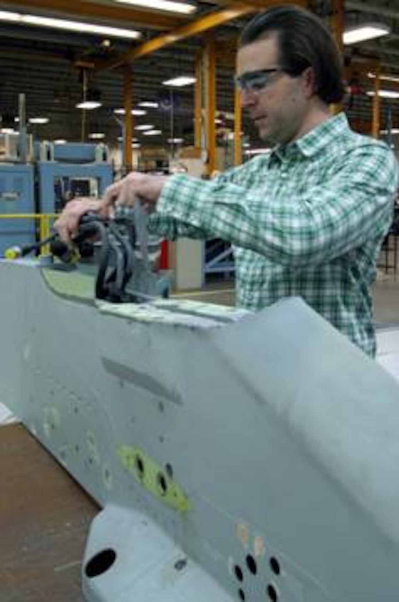 Timothy Smith, an ordnance systems mechanic with the 309th Commodities Maintenance Squadron at Hill AFB, Utah, stows cannon plugs in a newly machined F-16 pylon.  The updated pylons, fitted with a more hi-tech harness, ensure the aircraft can make use of 21st century smart weapons. (Air Force photo by G. A. Volb)

