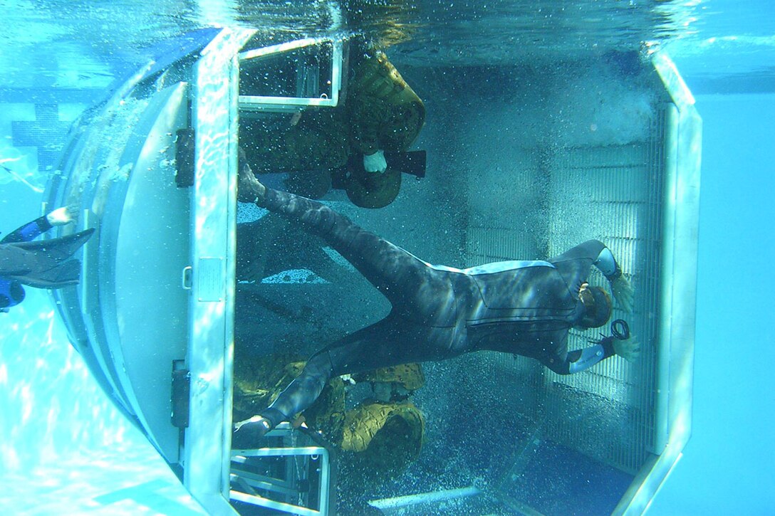 MARINE CORPS BASE CAMP PENDLETON Calif. (Feb. 14, 2006) - A "helo dunker" filled with Marines from the 15th Marine Expeditionary Unit rolls over under water while an instructor overlooks during a Basic Aircraft Ditching Course. 15th MEU Marines attended the course as training for a deployment later this year. Photo by Cpl. Scott L. Eberle
