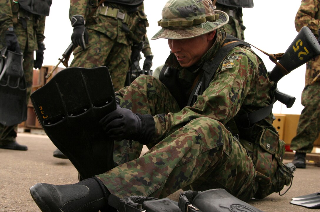 NAVAL AMPHIBIOUS BASE, CORONADO ISLAND, Calif. - A Japanese Ground Self Defense soldier puts on a fin and prepares to enter the San Diego Bay during a training exercise here Jan. 13. A company of 125 soldiers from the Land of the Rising Sun conducted Exercise Iron Fist alongside 30 Marines and sailors with Expeditionary Warfare Training Group Pacific, 1st Marine Expeditionary Force Jan. 9 - 27. The joint venture focused on amphibious warfare and was designed to improve the Japanese soldiers' ability to move from ship to shore.