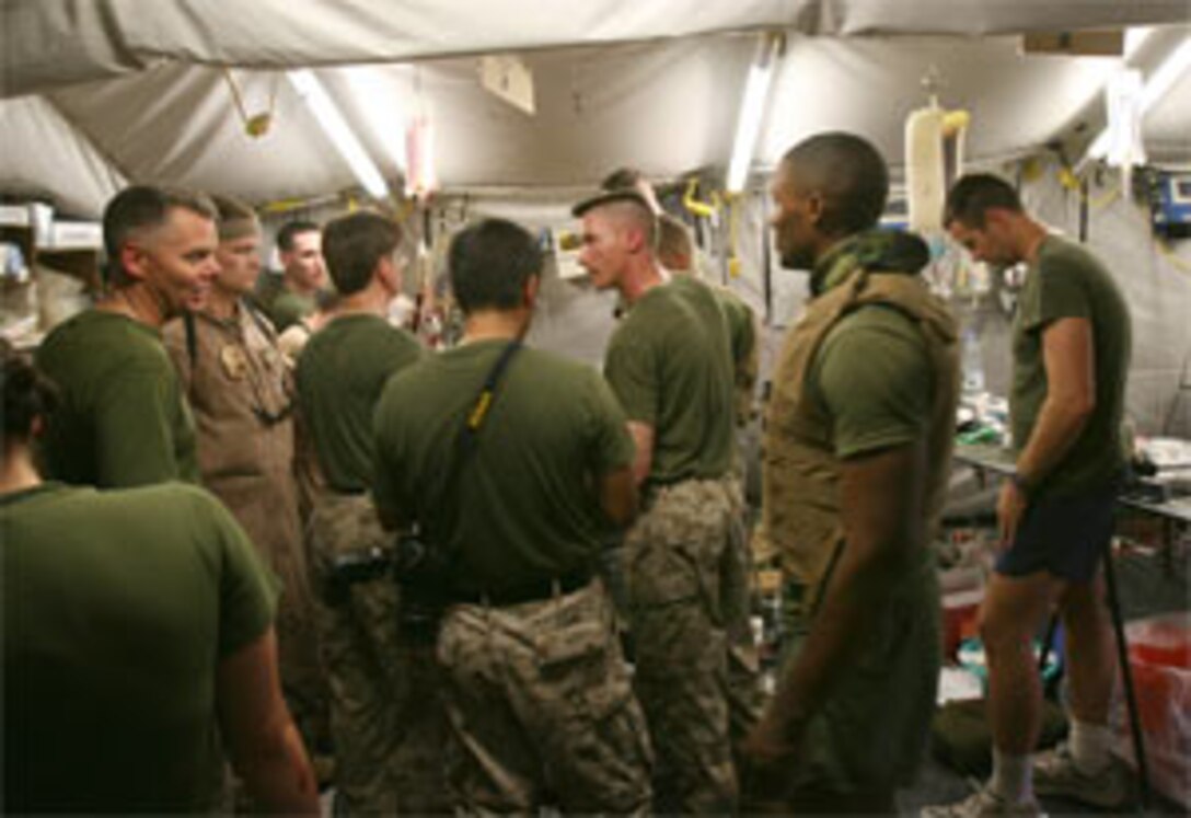 Naval medical personnel manage chaos April 13, 2006, as they treat wounded service members who just arrived at Camp Taqaddum?s main surgical facility for emergency medical treatment. The service members were injured in a recent insurgent attack in the Al Anbar Province of Iraq. Taqaddum Surgical handles the duties of both a shock trauma platoon and a forward resuscitative surgical suite, which are essentially makeshift emergency and operating rooms. When a service member is injured in battle in the Al Anbar Province, he receives specialized resuscitative treatment from the STP, with surgery provided by the FRSS. More extensive care is provided at one of the Combat Army Surgical Hospitals in Baghdad or Balad.